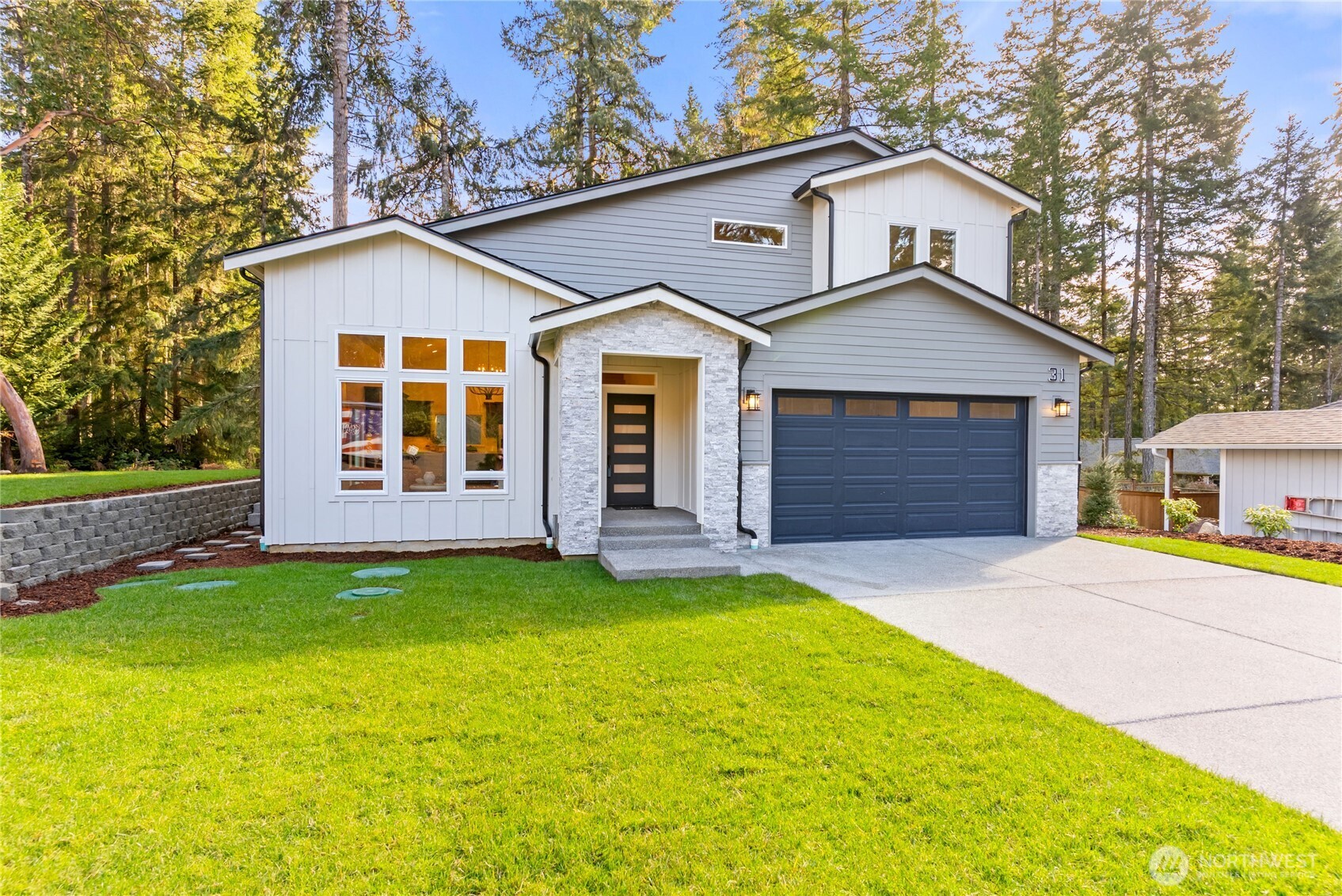 31 East Rhododendron Court Union, WA 98592 - Photo 2 of 38 a front view of a house with a yard and garage