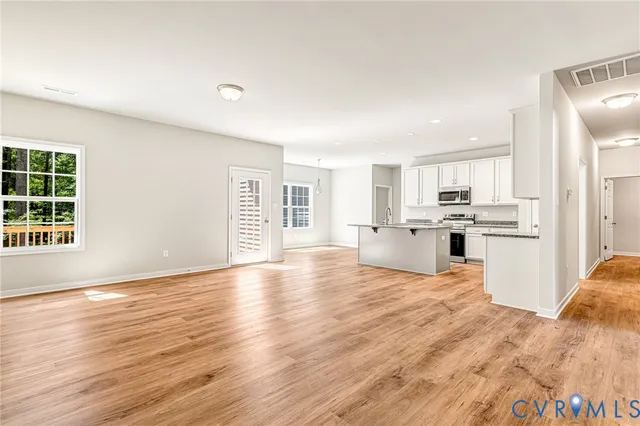 a kitchen with stainless steel appliances granite countertop a sink and cabinets with wooden floor