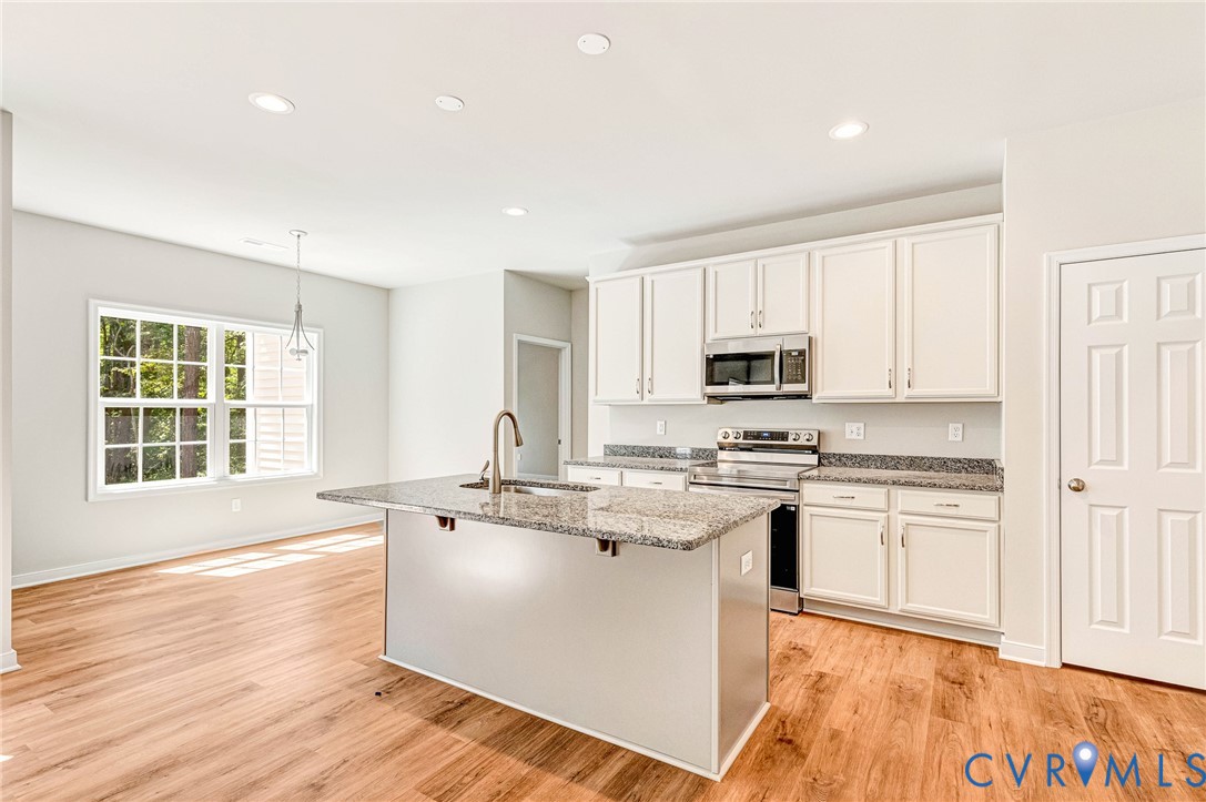 8355 Patrick Henry Boulevard Mechanicsville, VA 23116 - Photo 16 of 48 a kitchen with stainless steel appliances granite countertop a stove a sink dishwasher and a microwave oven with wooden floor