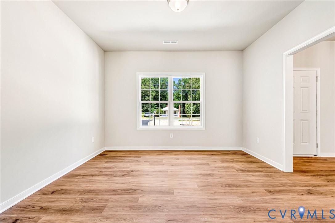 8355 Patrick Henry Boulevard Mechanicsville, VA 23116 - Photo 10 of 48 an empty room with wooden floor and windows