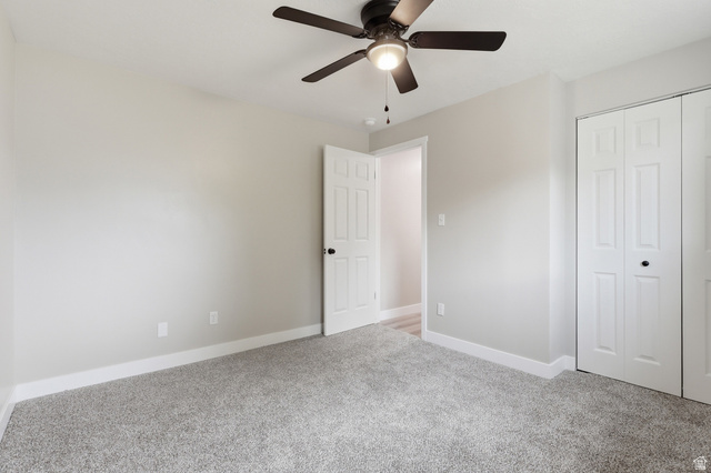629 King Circle Layton, UT 84041 - Photo 14 of 26 Carpeted room featuring a ceiling fan with integrated lighting, a paneled door with dark hardware, and bi-fold closet doors