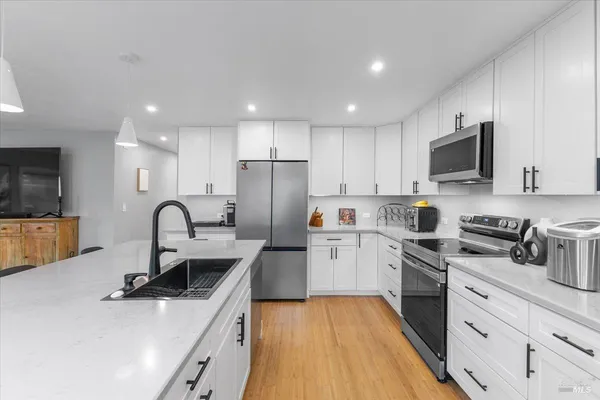 a kitchen with refrigerator a sink and a stove