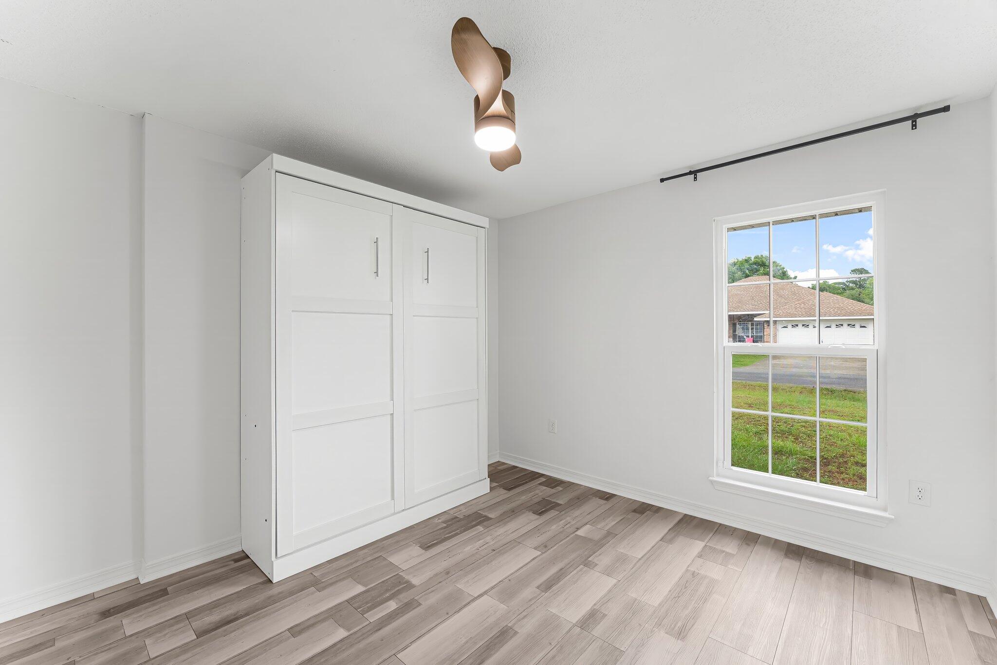 162 Beacon Way Santa Rosa Beach, FL 32459 - Photo 28 of 41 an empty room with wooden floor cabinet and windows