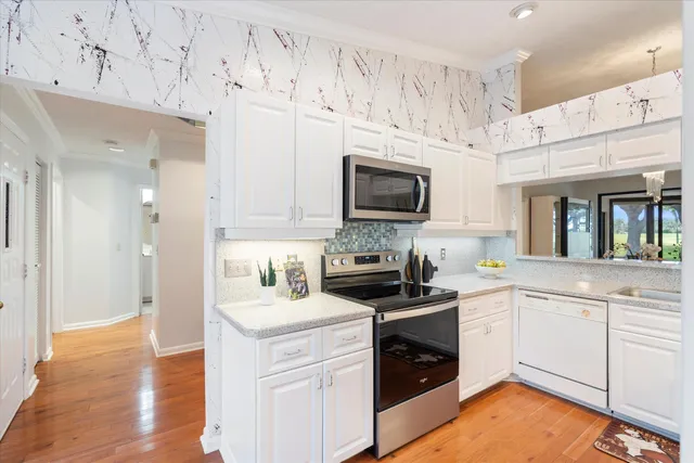 a kitchen with cabinets stainless steel appliances a sink and a stove top oven