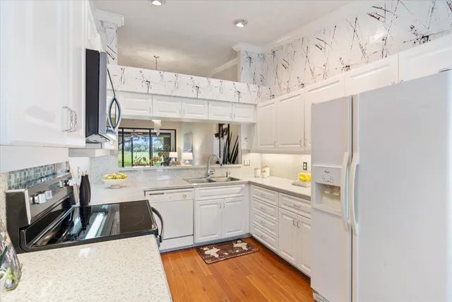 a kitchen with stainless steel appliances a sink a stove and a refrigerator
