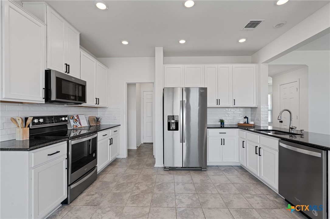 204 Benmyrtle Trail Georgetown, TX 78626 - Photo 15 of 35 a kitchen with stainless steel appliances granite countertop a refrigerator and a stove top oven