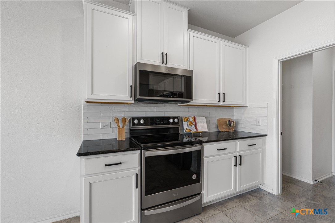 204 Benmyrtle Trail Georgetown, TX 78626 - Photo 17 of 35 a kitchen with white cabinets and stainless steel appliances