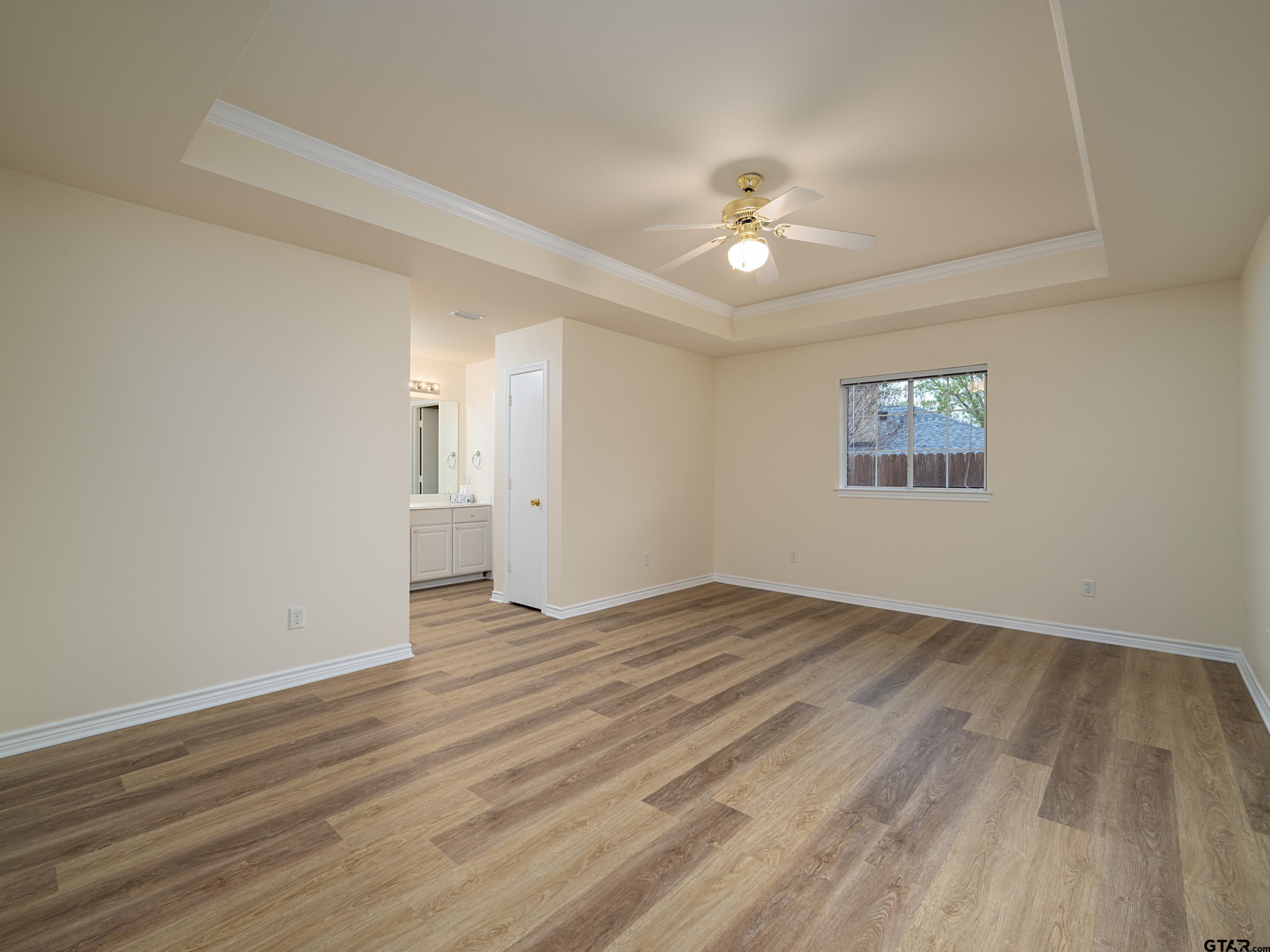 1521 Rice Road Tyler, TX 75703 - Photo 13 of 27 an empty room with wooden floor and windows