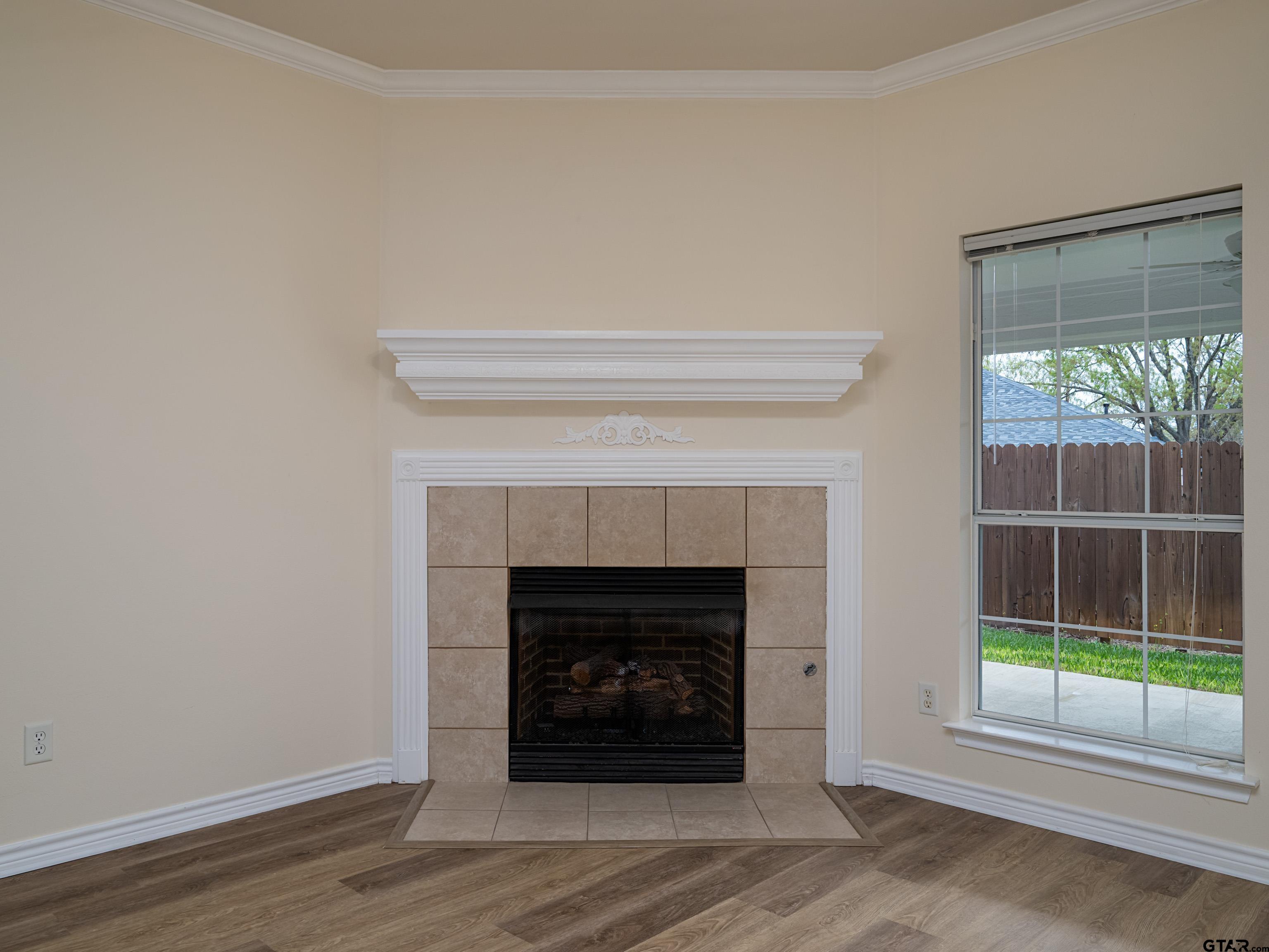 1521 Rice Road Tyler, TX 75703 - Photo 5 of 27 a living room with a fireplace and a floor to ceiling window
