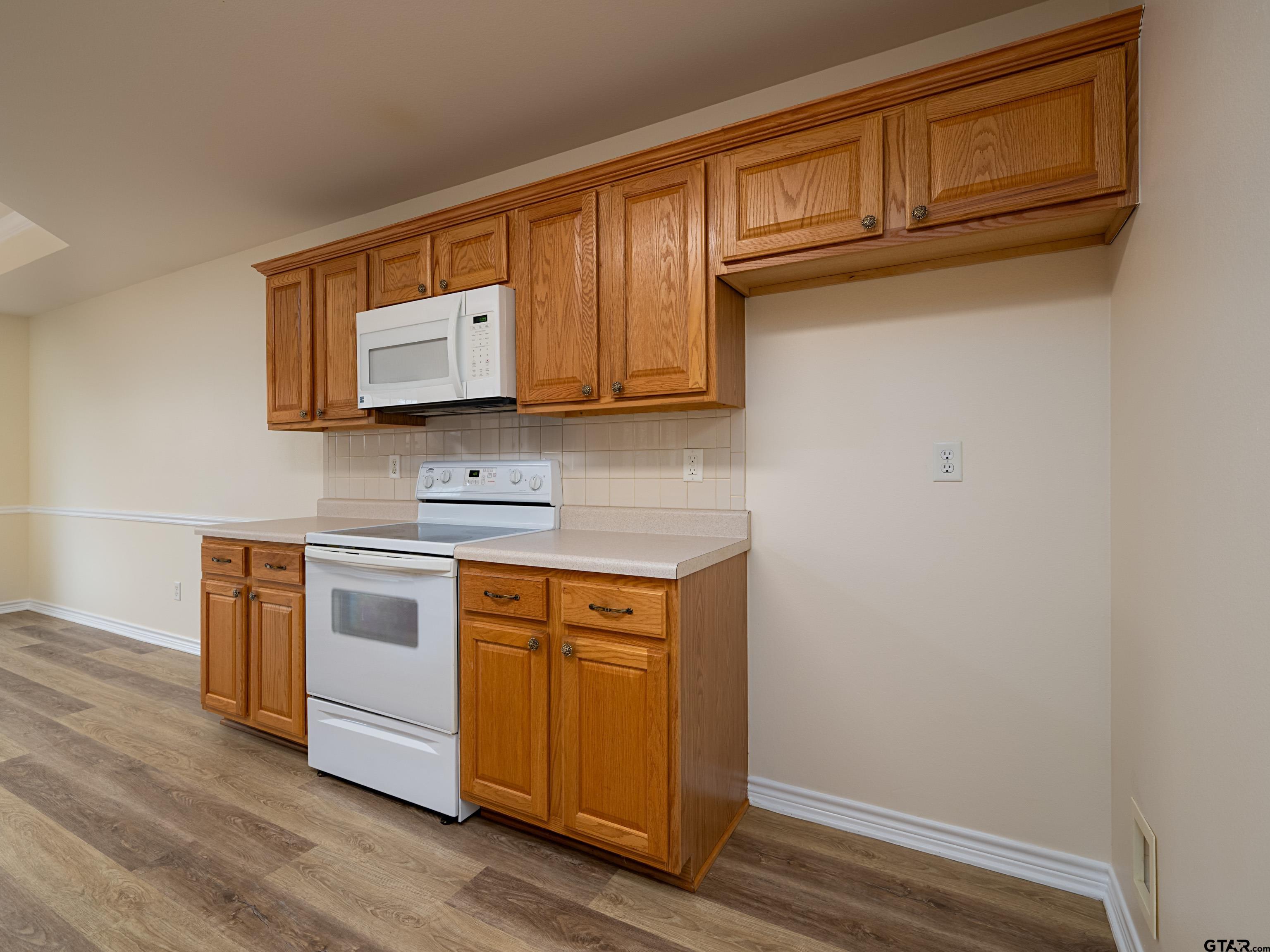 1521 Rice Road Tyler, TX 75703 - Photo 9 of 27 a kitchen with granite countertop cabinets stainless steel appliances and wooden floor