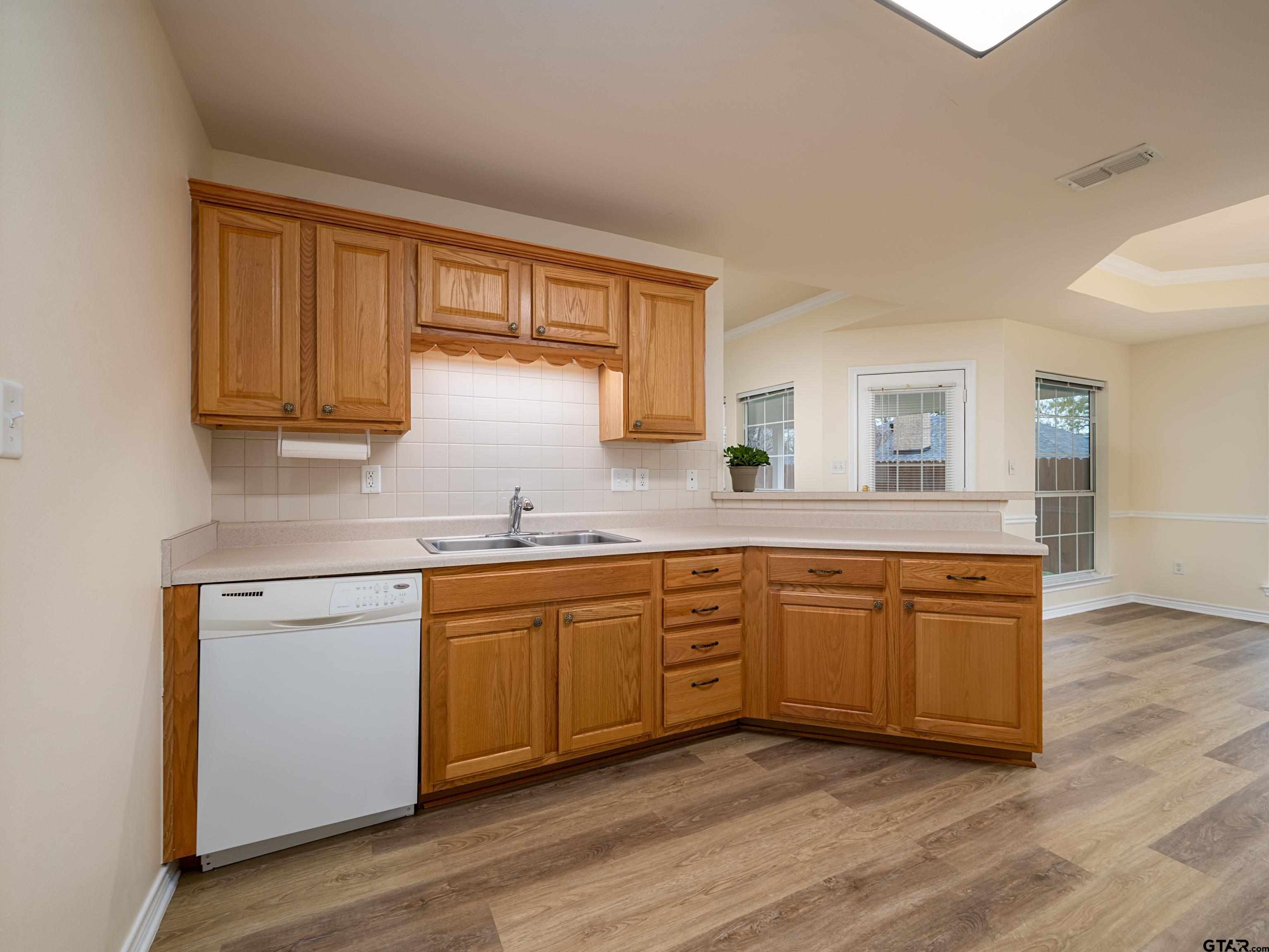 1521 Rice Road Tyler, TX 75703 - Photo 10 of 27 a kitchen with granite countertop wooden cabinets and a sink