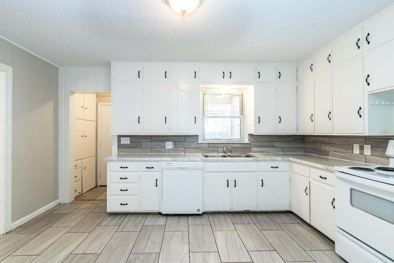 4212 42nd Street Lubbock, TX 79413 - Photo 8 of 18 a kitchen with granite countertop white cabinets and sink