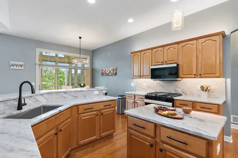a kitchen with stainless steel appliances granite countertop a sink stove and cabinets