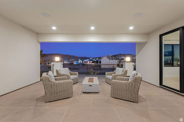4871 South Homestead Way Washington, UT 84780 - Photo 121 of 151 Patio at night featuring a patio area, an outdoor living space with a fire pit, and a residential view