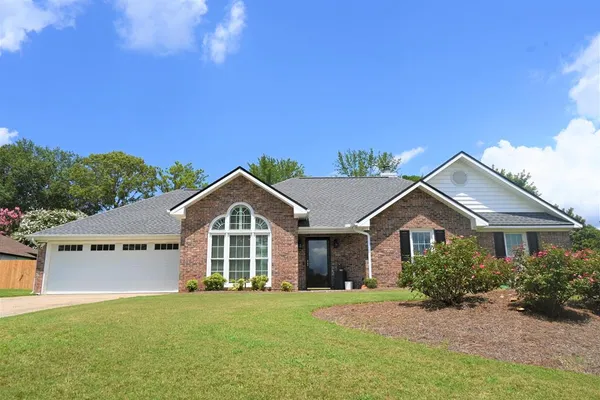 a front view of a house with a garden