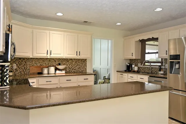 a kitchen with stainless steel appliances granite countertop a sink and cabinets
