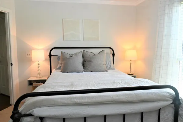 a large bed sitting in a bedroom next to a window