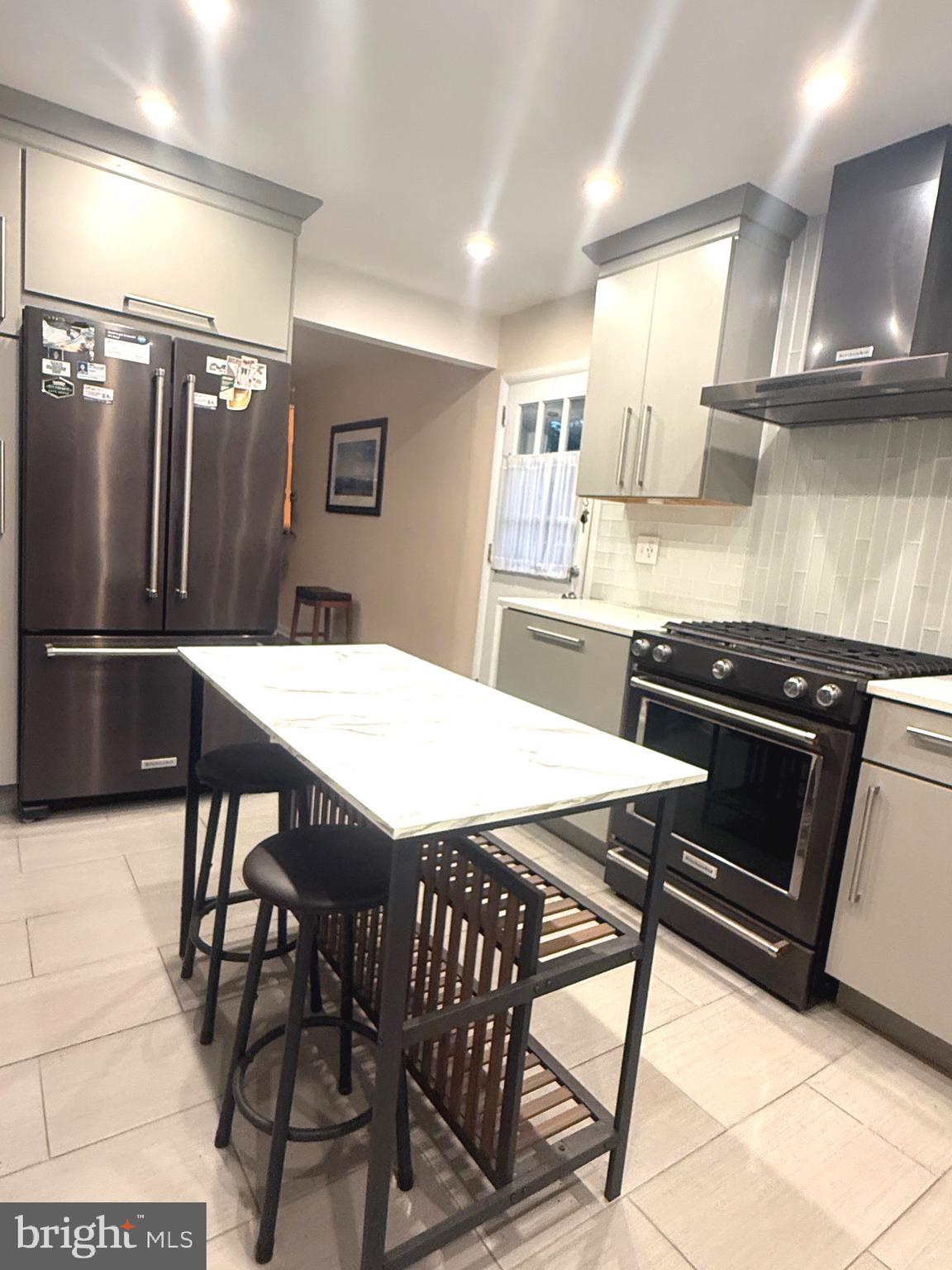 450 Foster Drive Springfield, PA 19064 - Photo 4 of 16 a kitchen with a table chairs and a refrigerator