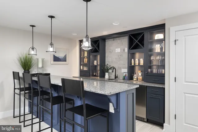 a kitchen with stainless steel appliances kitchen island granite countertop a table chairs in it and wooden floors