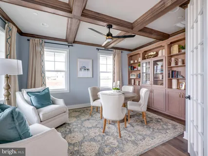 a living room with furniture a flat screen tv and a table