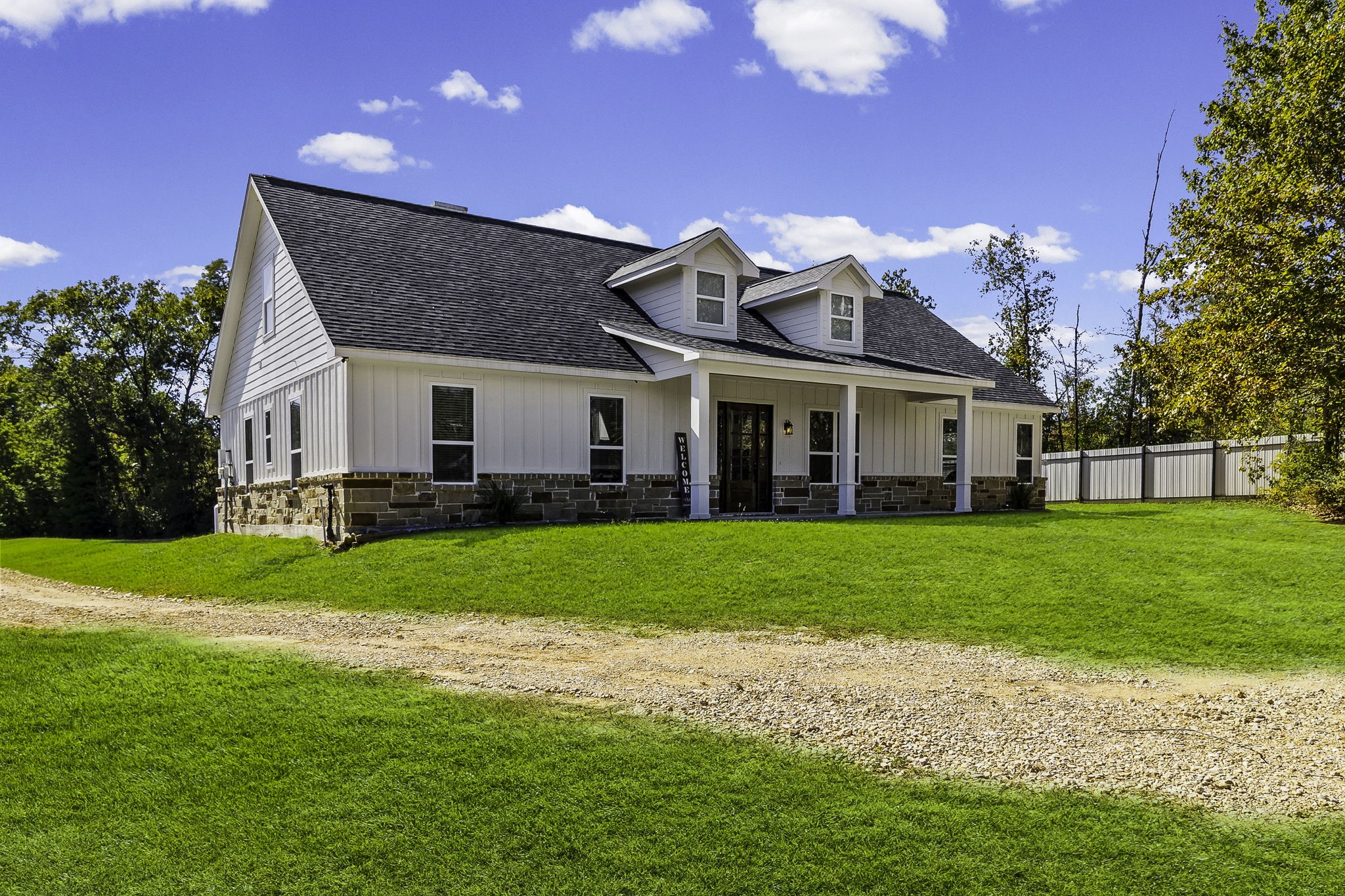 a view of a big house with a big yard and potted plants