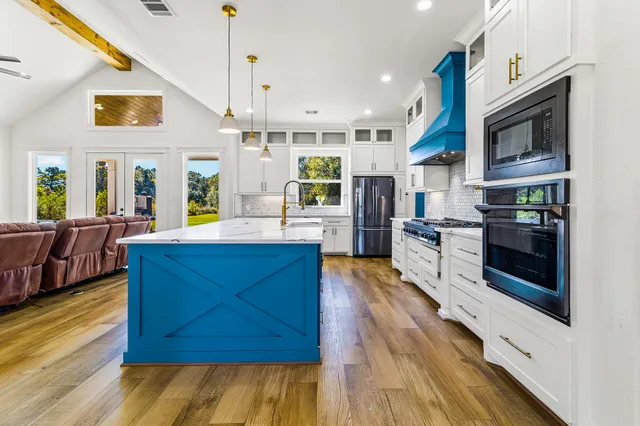 a kitchen with stainless steel appliances granite countertop a stove a sink and a refrigerator