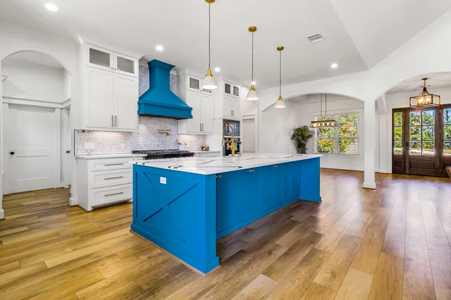 a large kitchen with stainless steel appliances granite countertop a stove a sink dishwasher and a refrigerator