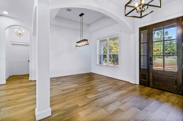 a view of hallway with wooden floor and a window