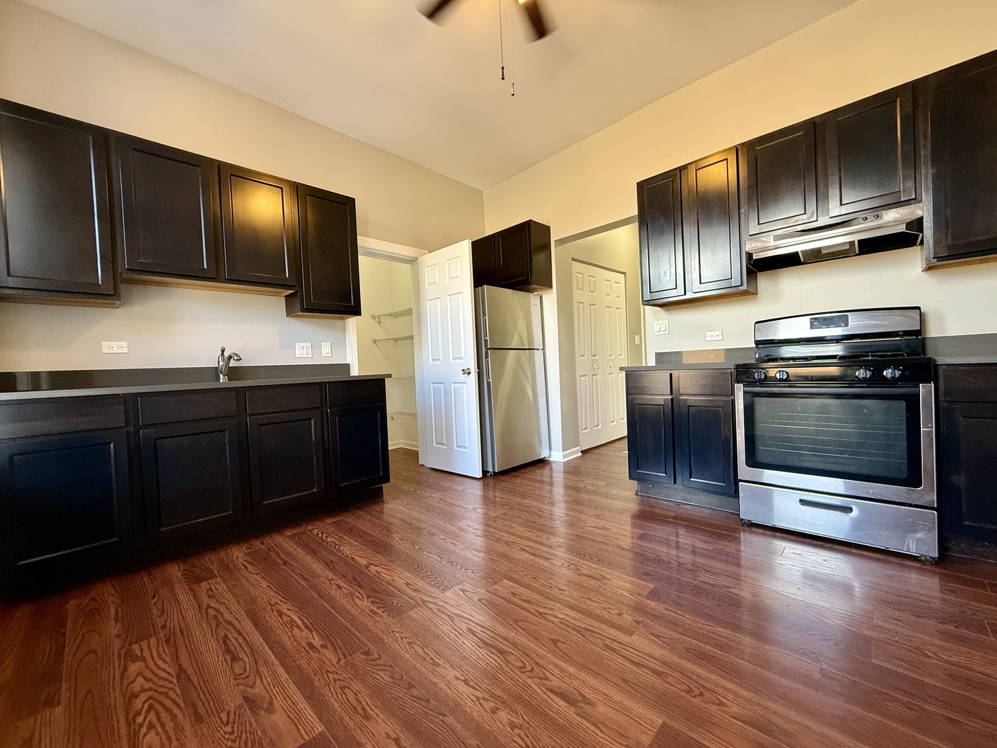 3235 South Racine Avenue, Unit 2M Chicago, IL 60608 - Photo 2 of 11 a kitchen with stainless steel appliances wooden cabinets and granite counter tops