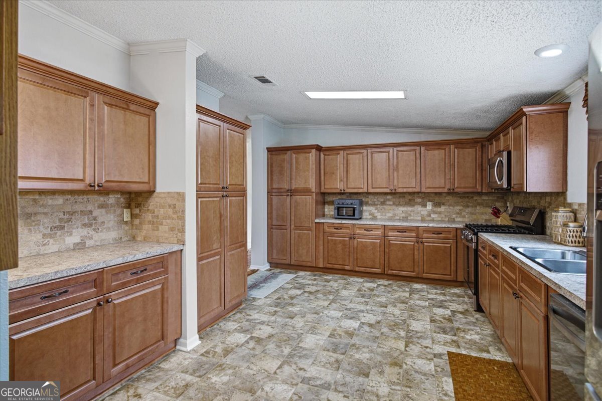 266 Payton Road Griffin, GA 30223 - Photo 16 of 48 a kitchen with stainless steel appliances granite countertop a refrigerator sink and cabinets