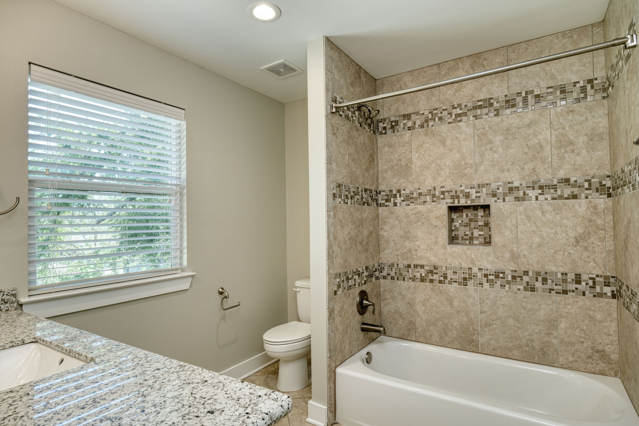 615 Spring Street, Unit 3 Round Rock, TX 78664 - Photo 7 of 14 Granite counters and tiled shower create a modern and functional bathroom space.
