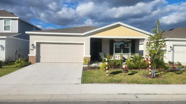 a view of a house with small yard plants and outdoor seating