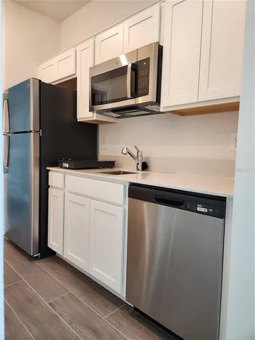 a kitchen with stainless steel appliances white cabinets and a refrigerator