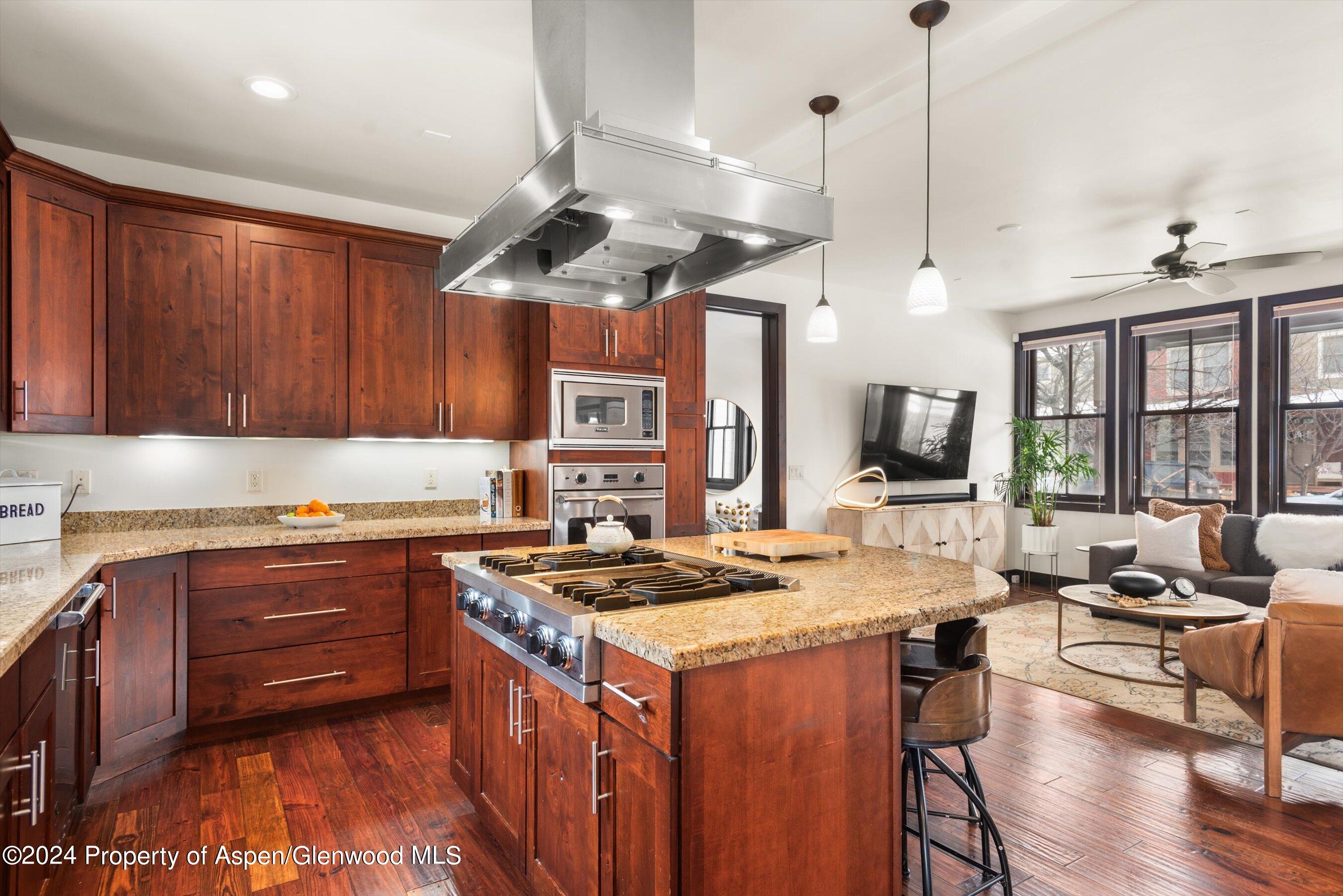 333 Sopris Circle Basalt, CO 81621 - Photo 16 of 57 a kitchen with a stove a sink a dining table and chairs with wooden floor