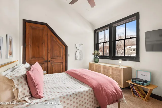 a bedroom with a bed and a dresser with mirror