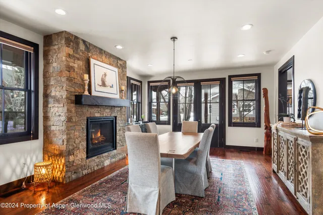 a dining room with furniture a fireplace and wooden floor