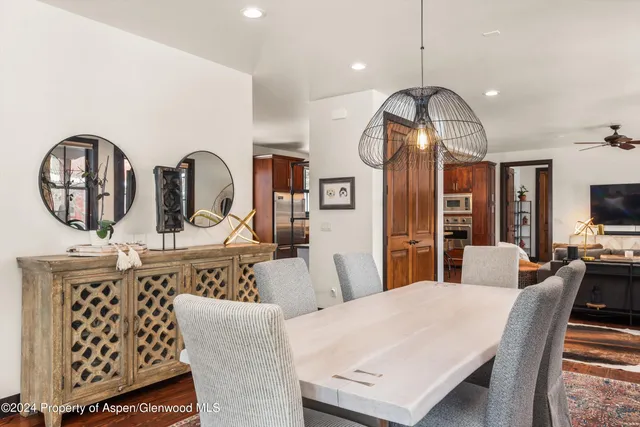 a dining room with furniture a rug a fireplace and a chandelier