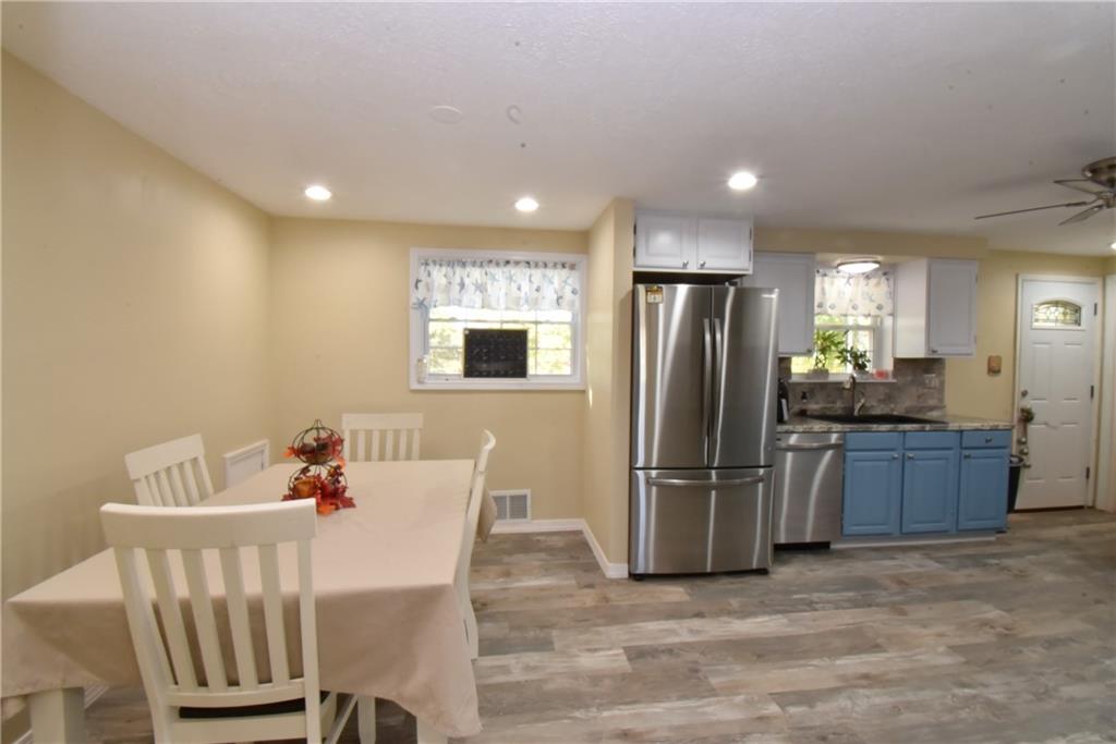 503 McKee Road Washington, PA 15301 - Photo 7 of 24 a kitchen with stainless steel appliances kitchen island granite countertop a refrigerator a stove a microwave oven with a dining table and chairs