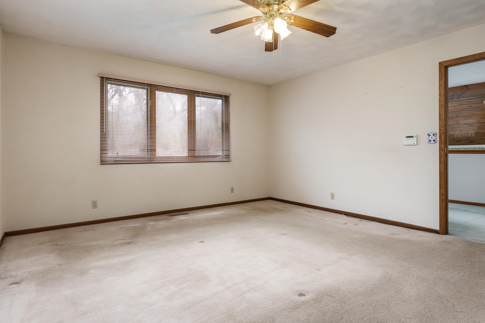 10245 Tybow Trail Roscoe, IL 61073 - Photo 31 of 63 an empty room with a chandelier fan and windows