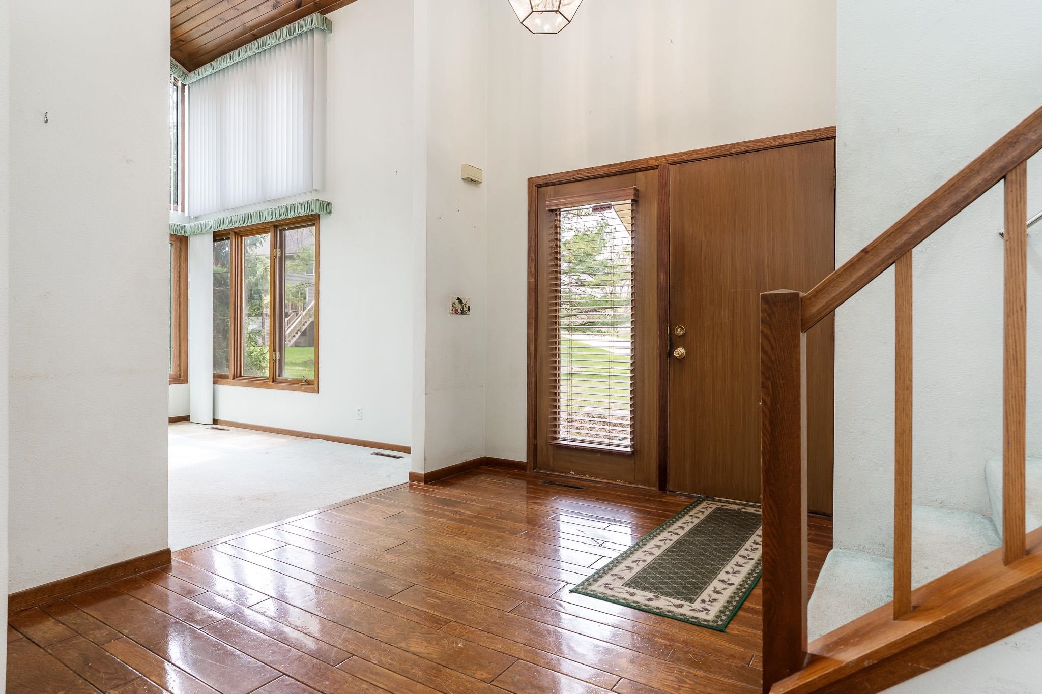 10245 Tybow Trail Roscoe, IL 61073 - Photo 4 of 63 a view of an empty room with wooden floor and a window