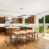 a dining hall with stainless steel appliances kitchen island granite countertop a dining table chairs and granite counter tops