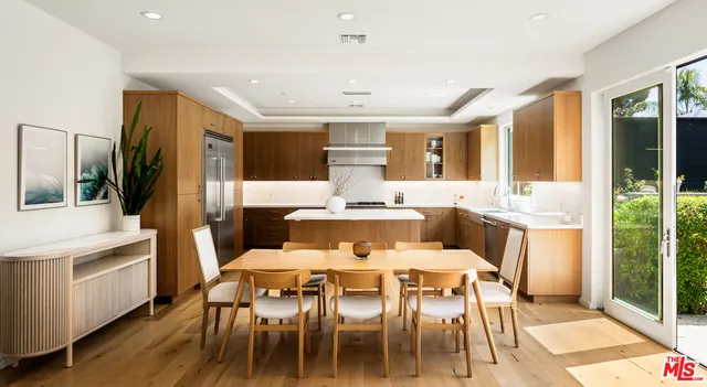 a dining room with stainless steel appliances kitchen island granite countertop a dining table and chairs