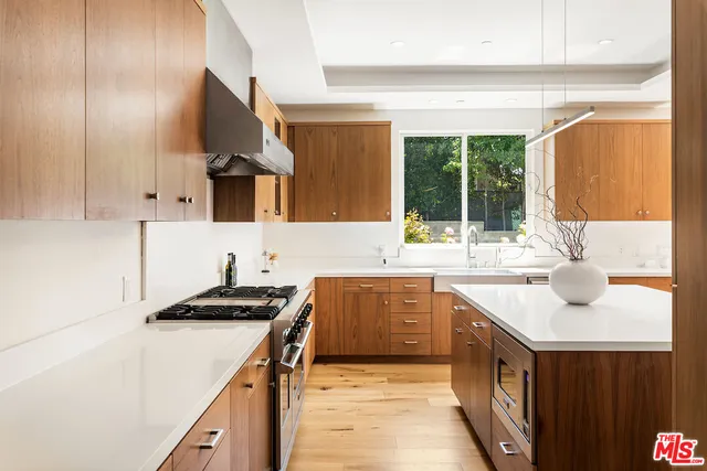 a kitchen with kitchen island granite countertop a sink and a stove