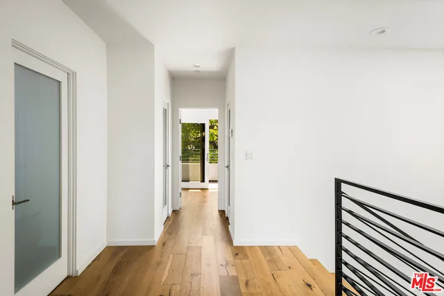 a view of a hallway with wooden floor and staircase