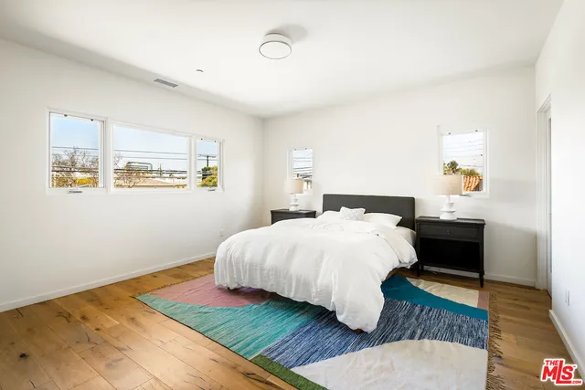 a bedroom with a bed and wooden floor