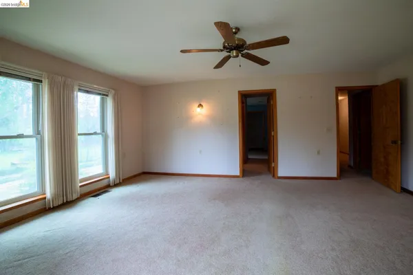 a view of a livingroom with a ceiling fan and window