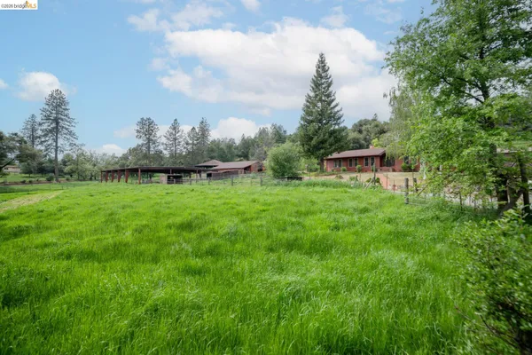 a backyard of a house with lots of green space table and chairs