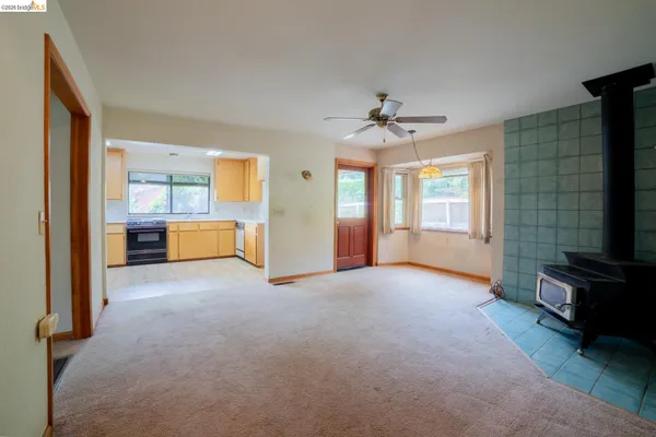 an empty room with windows and fireplace