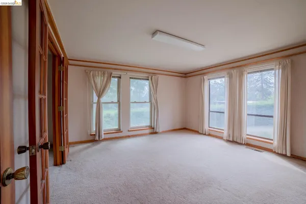 an empty room with windows and closet