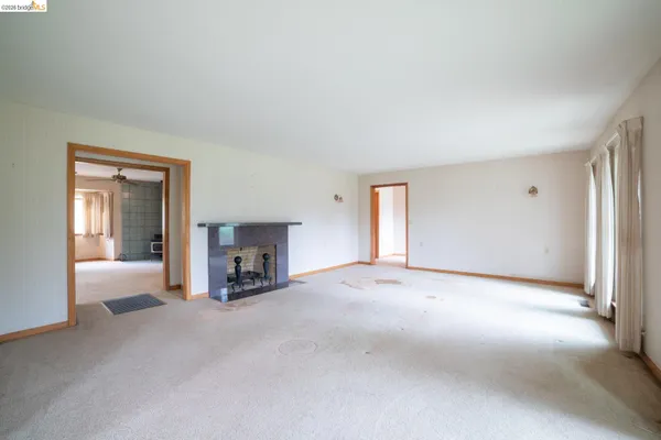 a view of a livingroom with fireplace and window